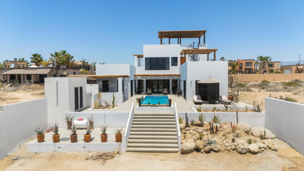 Chileno Bay El Posito We are excited to introduce Casa Elisabeth, an amazing, newly constructed custom home in the private El Posito area of Todos Santos. Located just three rows back from the beach, this three-bedroom, three-full and two-half bathroom residence offers every amenity desired for a tropical paradise. The downstairs features an open-concept living room, dining room, and a fully stocked kitchen with brand-new appliances, including a dishwasher. The main floor also includes a laundry room and an outdoor water feature with a professionally designed rock wall. The principal bedroom downstairs offers a unique indoor/outdoor bathroom with two showers and an outdoor bathtub.Each of the three bedrooms includes an en-suite bathroom with double vanities. The upstairs bedroom features its own private furnished terrace and access to one of four large patios, complete with a bar area and outdoor furniture perfect for enjoying ocean sunsets. Additionally, a shaded third-floor observation deck provides panoramic ocean and mountain – Casa Elisabeth, Pacific, Pacific, BS